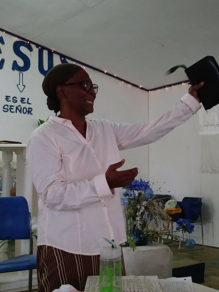 A woman holding up her purse in front of a crowd.