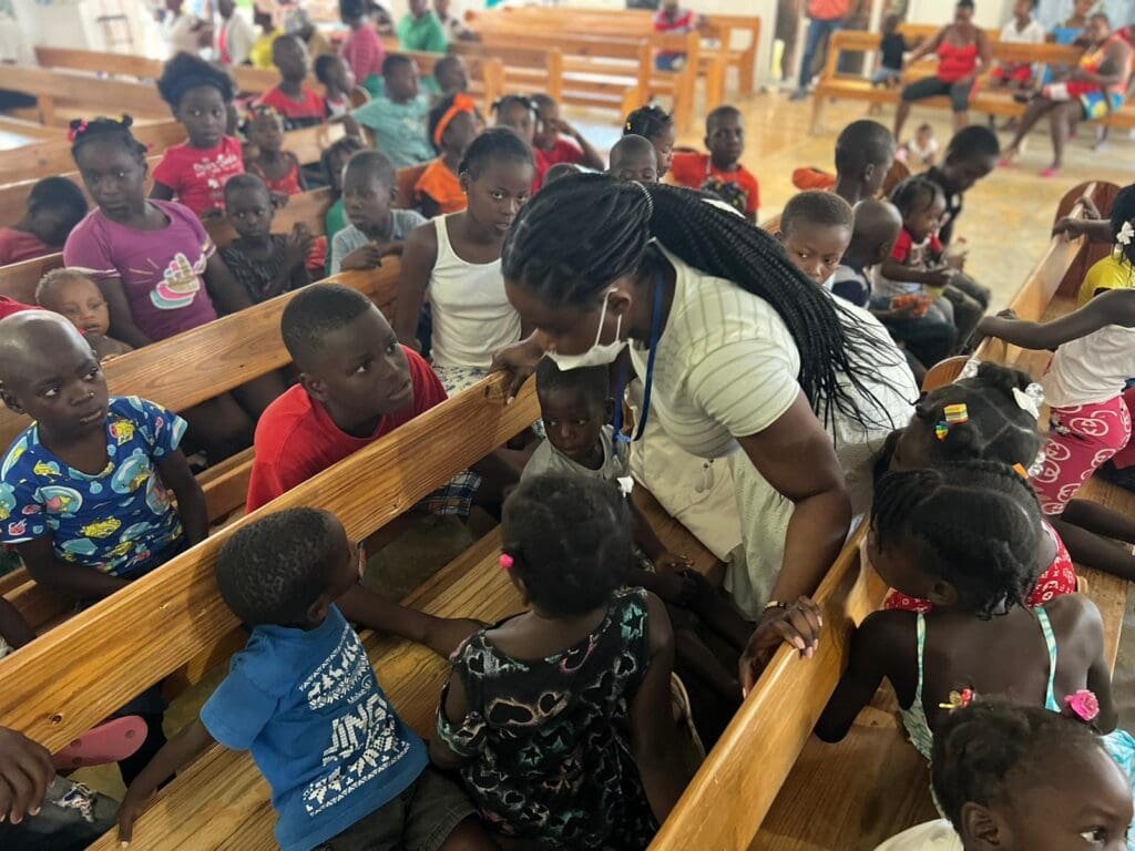 A woman is standing in front of some kids