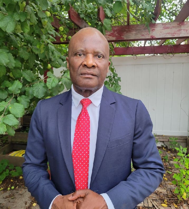 A man in a suit and tie standing outside.