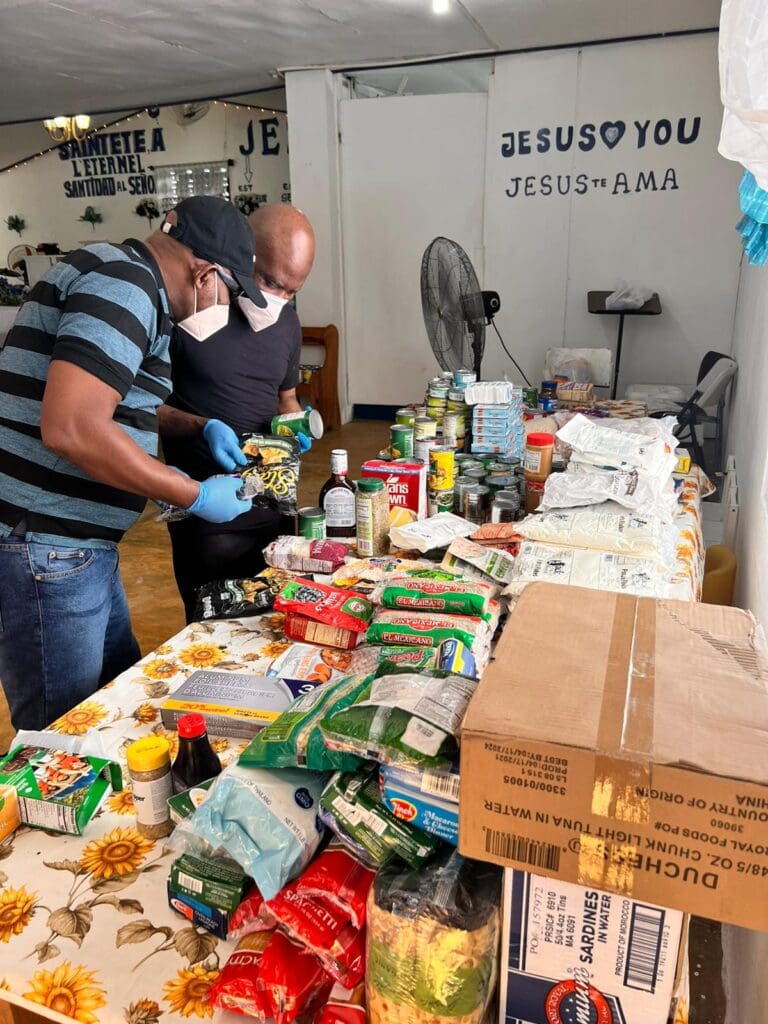 Two men are sorting food on a table.