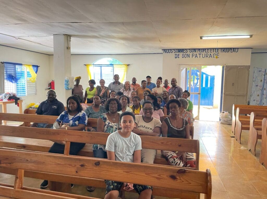 A group of people sitting in pews at the church.