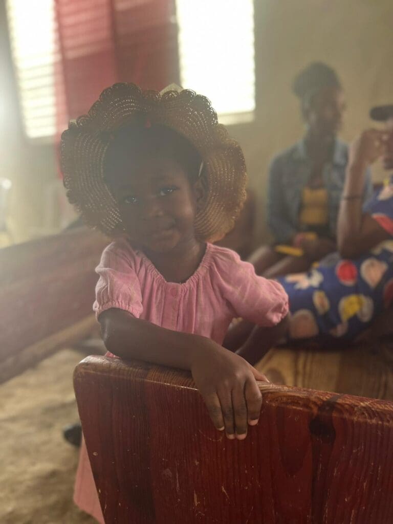 A little girl sitting on top of a wooden box.