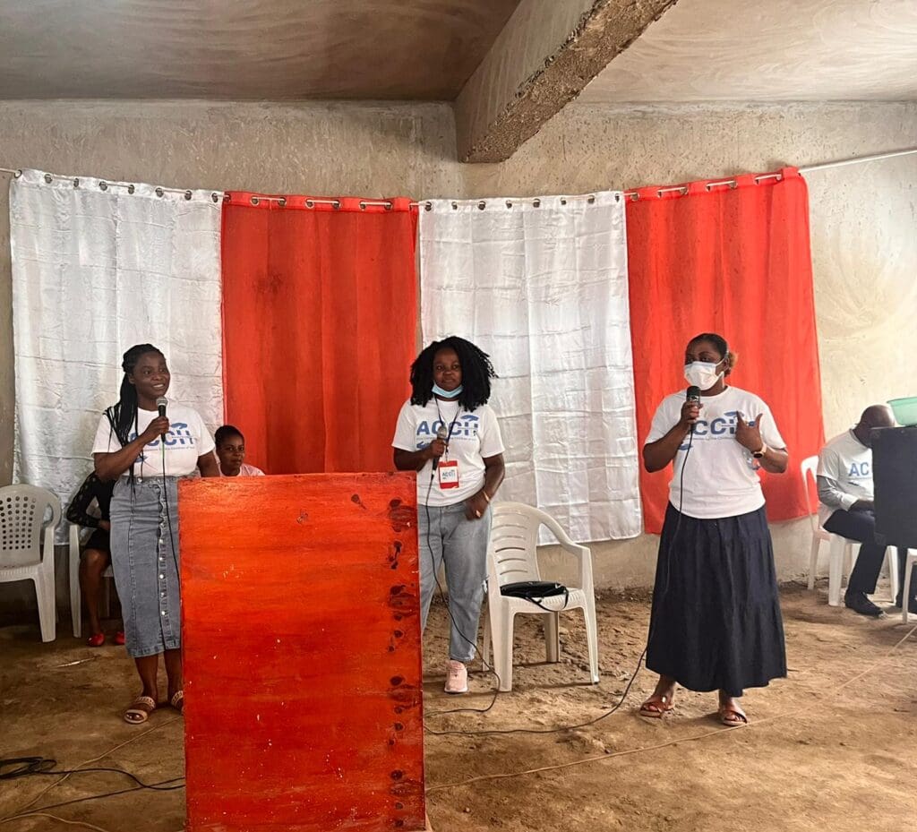 A group of people standing in front of red curtains.