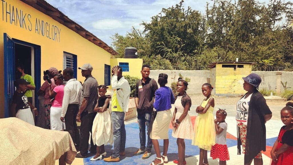 A group of people standing around in front of a building.