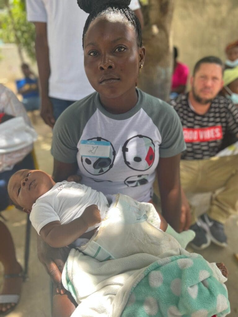 A woman holding a baby in her arms.