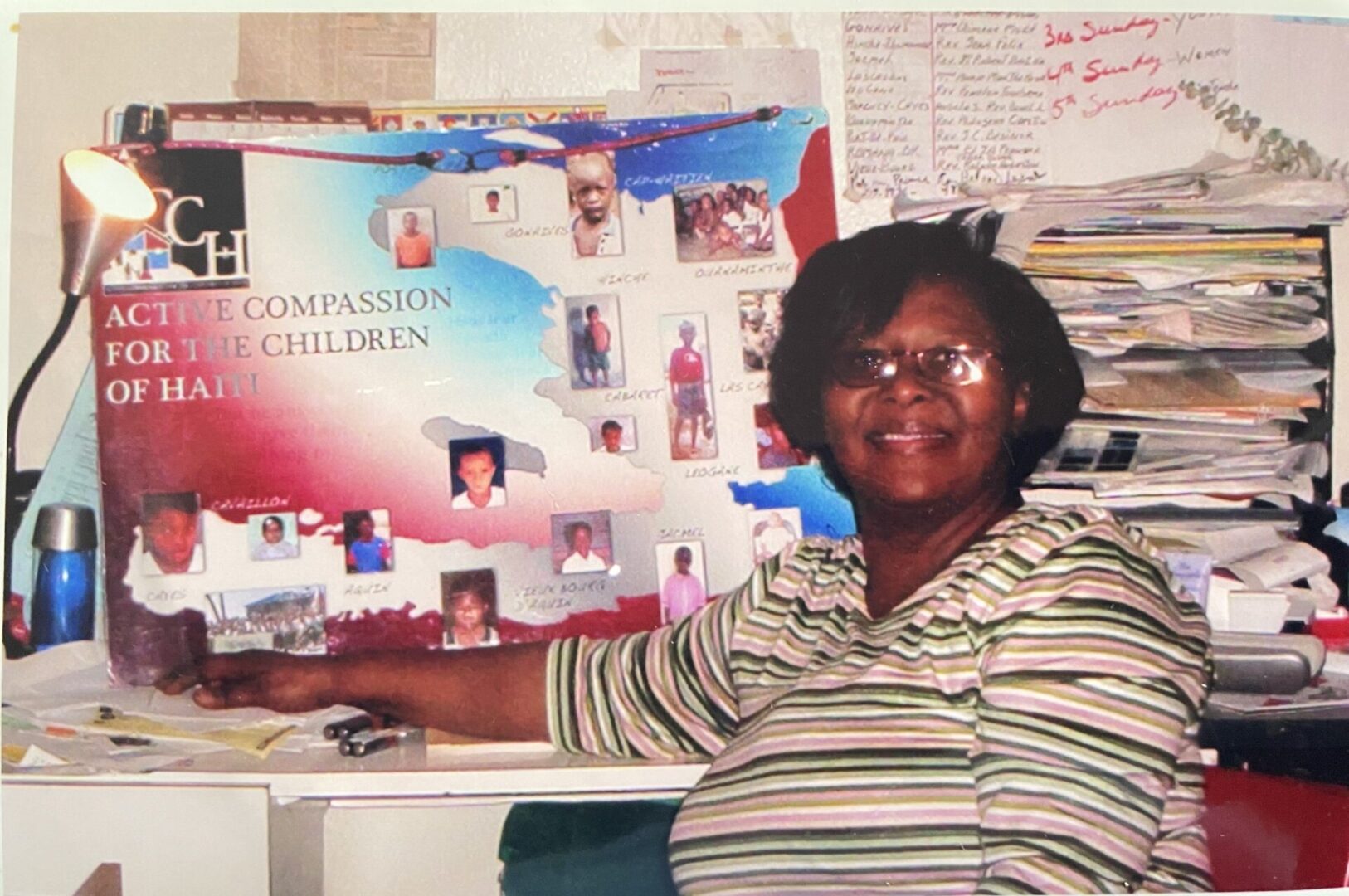 A woman standing in front of a wall with pictures on it.