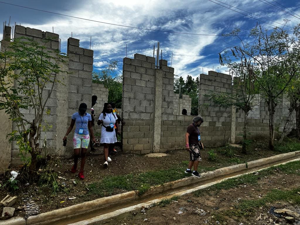 A group of people standing next to a wall.